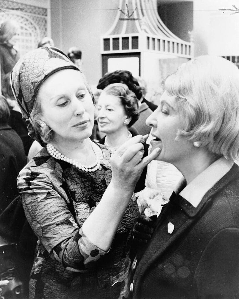 Estée Lauder puts makeup on a customer in 1966 (Wikimedia Commons).