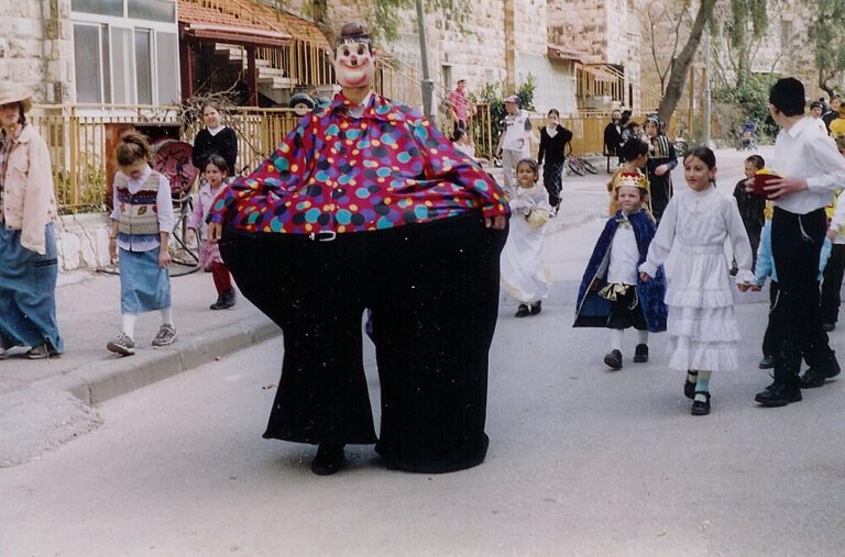 Children dressed in costume and carrying mishloach manot follow a costumed clown on Purim day in Jerusalem, Israel. (Wikimedia Commons)