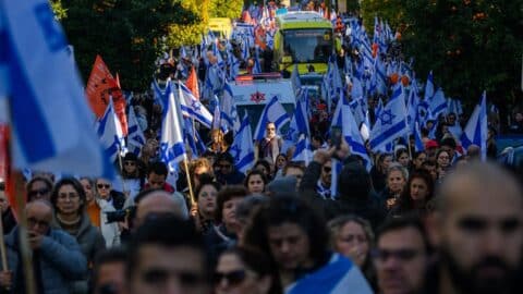 Thousands of people line the street to watch and pay their respects as the funeral procession carrying the caskets of Shiri Bibas, Kfir Bibas and Ariel Bibas pass by with the family in minibuses behind them on its way to the funeral on February 26, 2025 in Rishon LeZion, Israel.