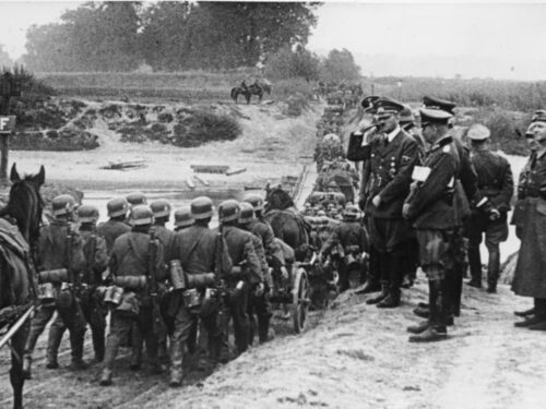 Hitler watching German soldiers march into Poland in September 1939.