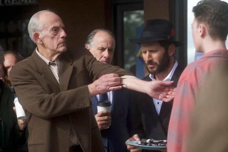 Christopher Lloyd as a Holocaust survivor showing his tattoo in "Guns & Moses."