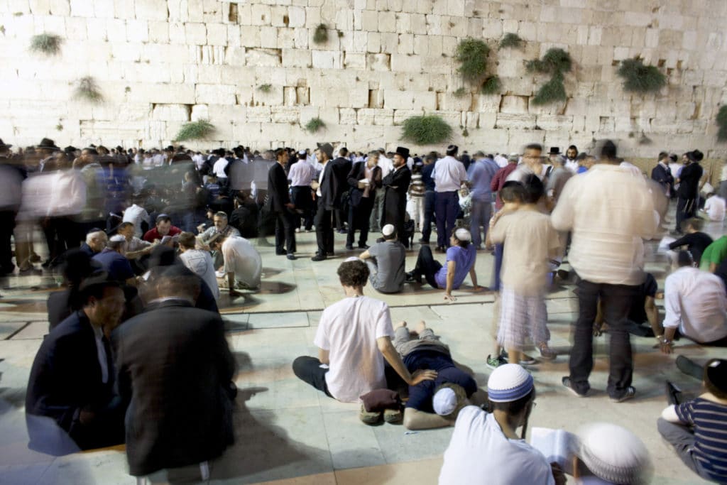 Religious Jews read from Eicha, the Book of Lamentations as they observe Tisha B’Av on August 8, 2011 at the Western Wall in Jerusalem. (Photo by Uriel Sinai/Getty Images)