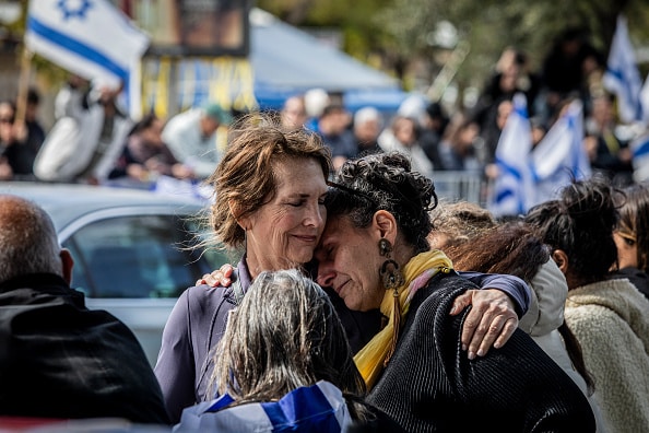 TEL AVIV, ISRAEL - 2025/02/20: Two women comfort each other as they wait for the convoy transporting the bodies of Israeli hostages out side the Abu Kabir National Center for Forensic Medicine. Hamas released the bodies of four Israeli hostages, the remains were said to be of Shiri Bibas and her two children, Ariel and Kfir, as well as Oded Lifshitz, who was 83-years old when he was abducted. Hamas said that all four were killed along with their guards in an Israeli airstrike. (Photo by Eyal Warshavsky/SOPA Images/LightRocket via Getty Images)
