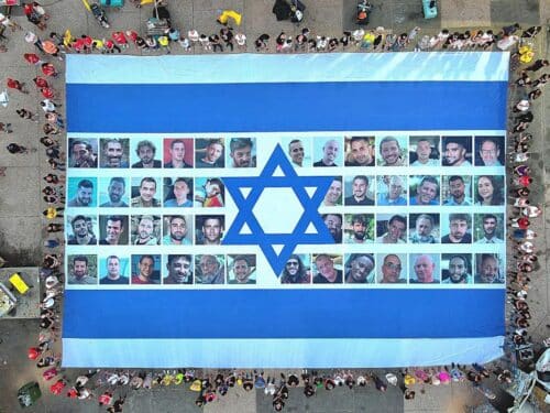 Protesters gather in Hostage Square and hold a giant Israeli flag with photos of hostages on it, demanding the return of the hostages held in Gaza, as protests and strikes continue in Tel Aviv, Israel on August 17, 2025. (Photo by Yair Palti/Anadolu via Getty Images)