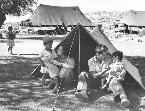A soldier plays with a refugee child, 1951 (Wikimedia Commons)