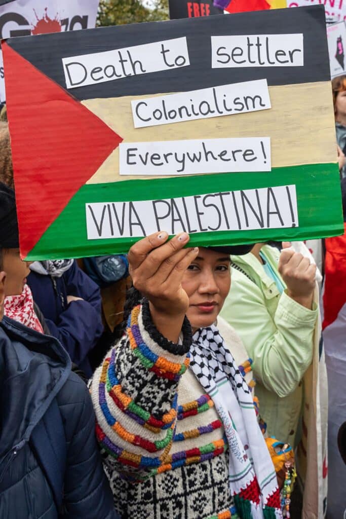 A pro-Palestinian protester holds up a sign reading "Death to settler colonialism everywhere! Viva Palestina!" before a march through central London in support of Palestinians on Oct. 21, 2023 in London, United Kingdom. (Photo by Mark Kerrison/In Pictures via Getty Images)