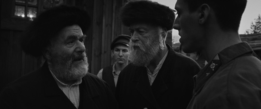 Saul Rubinek as the rabbi, stares at Lobel, who plays Moshe, trying to explain his thoughts.
