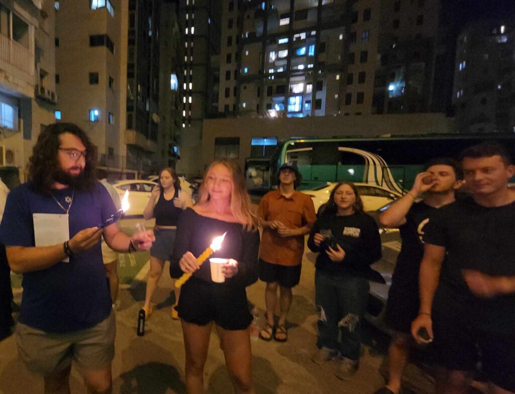 Melinda Harz holding a candle during Havdala.
