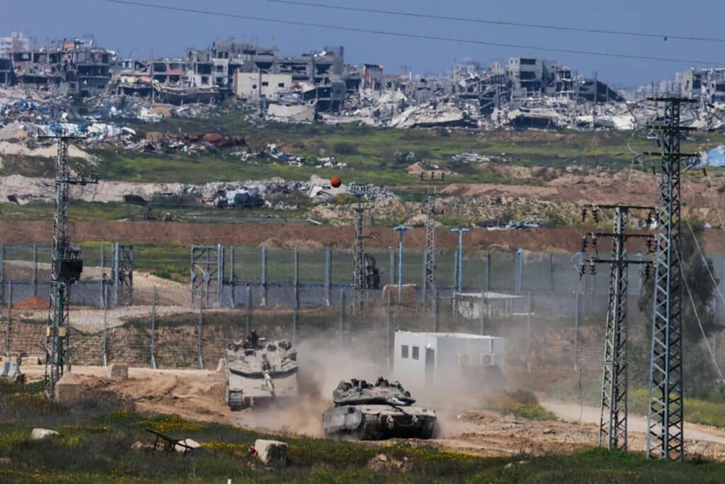 Israeli army Merkava main battle tanks move at a position in southern Israel along the border fence with the northern Gaza Strip on March 18, 2025.