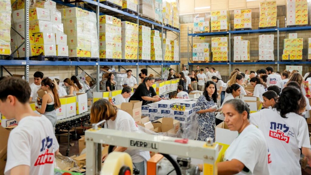 Volunteers packing aid boxes in Latet’s warehouse in Beit Shemesh. Photo courtesy of Latet